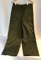 Front view of olive green vintage military fatigues trousers, showing high waist, button fly, and large buttoned cargo pockets on each leg.
