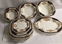 Top-down view of entire set showing stacked dishes, bowls and serving plate with Imari pattern