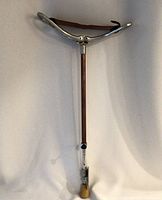 Full view of wooden adjustable walking cane with silver-tone top handle and rubber tip at base