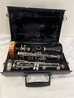 Clarinet disassembled inside black case with cork grease and mouthpiece visible