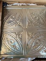 Stack of new unfinished tin ceiling tiles in box