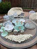 Complete set displayed on outdoor round table including glass domes and bases, candle holders, timers, and wall plaque.