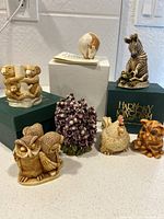 Photo showing seven figurines arranged together, including two in green Harmony Kingdom boxes and one white box.