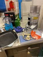 Overview of all items on countertop including cookware, processors, coffee set and waffle maker