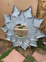 Full view of galvanized steel round flower mirror showing aged distressed look and three-dimensional petal design.