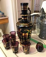 Decanter set with decanter and six matching glasses on a table.