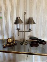 Full lot showing metal desk lamp with two shades, Donato pen and quartz clock set on a wooden base, and wood hideaway with two trays.