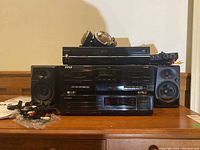 Front view showing stacked Toshiba DVD/VCR, Pyle cassette deck, Pioneer CD player, Pioneer speakers, cables, and Koss headphones on top