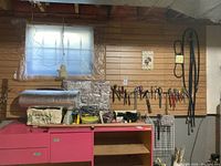Wall and bench with assorted tools hanging and placed on bench