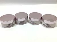 Four jars of Shiseido White Lucent Brightening Moisturizing Cream arranged in a row, showing the front labels and lids to identify brand and product line.