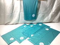 Five turquoise cooling multi-band fabric neckwarmers laid flat with one displayed vertically.
