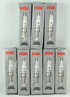 Eight NGK Laser Iridium spark plugs in original packaging, arranged in two rows showing front of boxes and spark plugs.