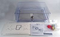 Clear large plastic Honeywell thermostat guard with lock, keys, mounting hardware, and installation instructions displayed on flat surface.
