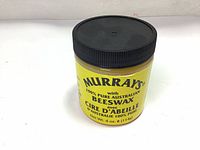 Photo of the front label of Murray's Beeswax pomade jar showing branding and net weight.