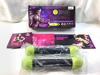 Photo of two Zumba toning sticks in plastic wrap along with a set of five DVDs and a fold-out exercise program guide, with boxed packaging visible behind.