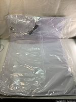 Bed sensor pad packaged flat in clear plastic showing cable connection on upper left corner.