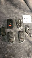 Front view of six assorted car remotes with buttons visible.