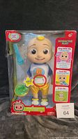 Front view of the unopened CoComelon Deluxe Interactive JJ doll in original box with accessories visible.