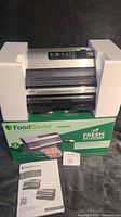 FoodSaver FM5200 vacuum sealer with original box and owner's manual, protected by foam inserts.