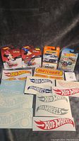 Photo shows two Hot Wheels Disney cars featuring Mickey and Minnie Mouse in original packaging, one Matchbox white utility truck, and multiple Hot Wheels and Matchbox stickers laid out.