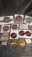 Photo showing a variety of Hot Wheels garage and anniversary stickers in vibrant colors, arranged on black background.