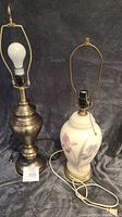 Two lamps shown side by side on a dark backdrop, without lampshades. One lamp is metal with a brushed finish, and the other is ceramic with floral decoration.