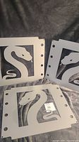Three metal artwork panels with python snake cut-out design, showing overall condition and details.