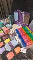 Photo showing multiple stacks of Scentsy wax bars in various colors placed next to colorful plastic storage containers and the large Scentsy bag.