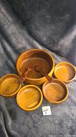 Full set of seven wooden pieces including large bowl, four small bowls, wooden spoon and fork visible showing the overall lot contents