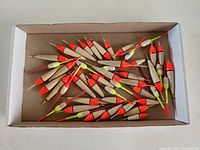 Box of new fishing bobbers of various colors and sizes