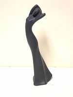 Side view of the matte black Royal Doulton "Yearning" figurine showing elongated female figure with arms raised.
