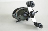 Angled view of Shimano Bantam Curado CU-200 fishing reel showing side plate with model number and handle.