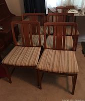 Group shot of six chairs showing teak frames and striped upholstery.