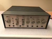 Front angle view showing metal chassis, silver faceplate, control knobs and perforated top.