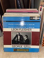 Front cover of a blue and maroon classical album featuring Leon Fleisher and George Szell with The Cleveland Orchestra, titled Piano Concerto in A Minor.