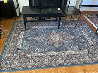 Full view of the patterned area rug with furniture placed on it showing overall design and size.