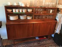 Front view showing full cabinet with display shelves holding tableware