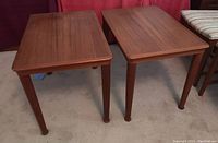 Two teak end tables shown side by side from front