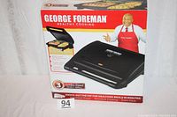 Photo of the boxed George Foreman Healthy Cooking Jumbo Size Family Grill, showing front packaging with image of the grill and George Foreman.