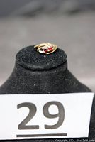 Front view of 10K gold ring with two red stones, showing the overall ring on black display stand with lot number 29.