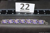 Full length photo of the bracelet with a ruler showing approximately 7 inches long.