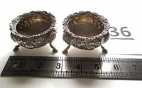 Pair of salt cellars beside ruler spanning 0-7 inches showing size
