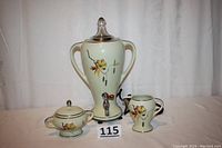 Full view of three-piece coffee set with electric percolator, sugar bowl, and creamer showing floral pattern and colors