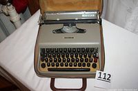 Front view of Olivetti Lettera 22 typewriter in open case with keyboard visible showing layout and keys.