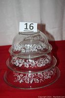 Three clear glass bowls with white cornflower floral design stacked nested inside each other.