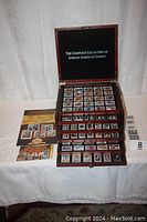 Open display case showing multiple rows of African-American themed stamps and accompanying collection brochures.