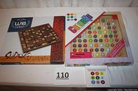 Photo showing two boxed Sudoku games, one by we Games with wooden design, and one Color Sudoku puzzle with colorful marbles.