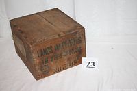 Closed view of wooden box showing stenciled title 'Lands and Peoples The World in Color No. 7801' on top and side edges with dovetail box joints.