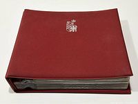 Closed red hardcover custom display album embossed with silver Westminster Collectors Society emblem on front, showing thickness and binding