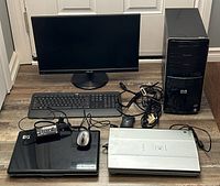 Full view of all electronic items on floor including HP desktop tower, HP laptop, Canon scanner, Logitech keyboard and mouse, Asus monitor